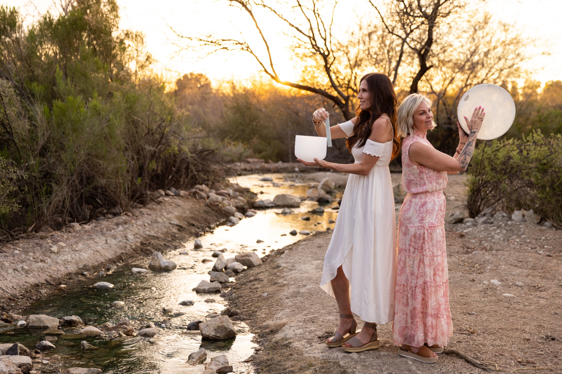 Brooke Bishop playing crystal singing bowls in a sunlit forest
