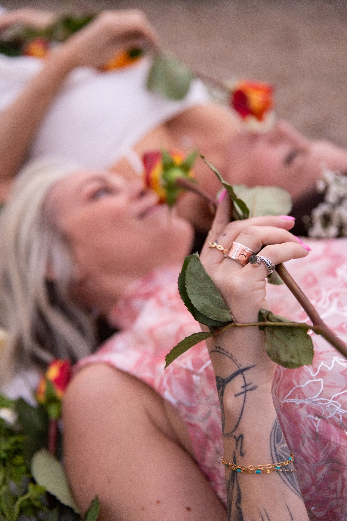 Women resting among flowers in a soft, intimate ritual setting